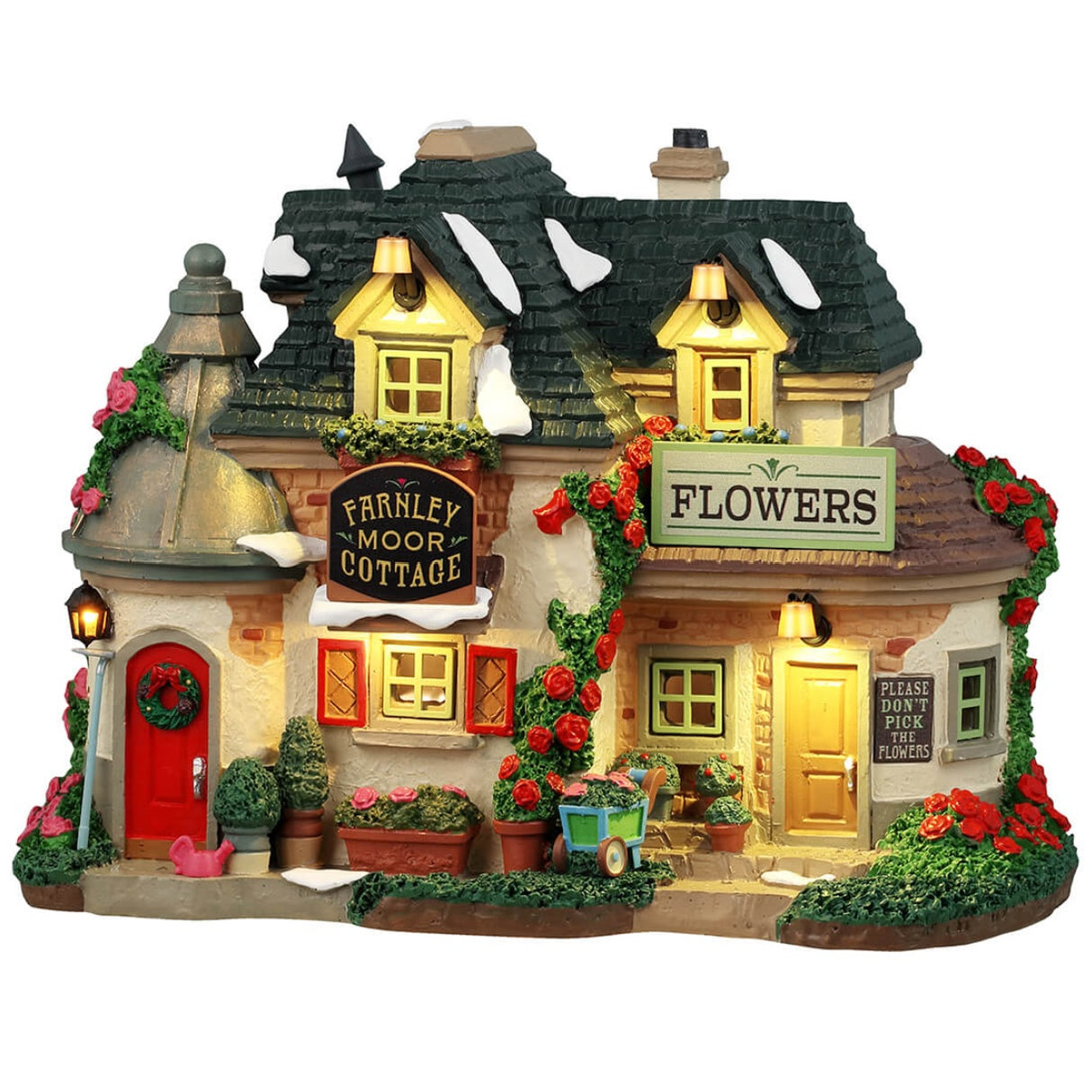 Resin lighted building for a Lemax display. Designed to look like a charming cottage covered in moss and flowers. There's a bright red door with a decorated wreath on it. There are signs that read "Farnley Moor Cottage," "Flowers" and "Please don't pick the flowers." There's snow on the roof.