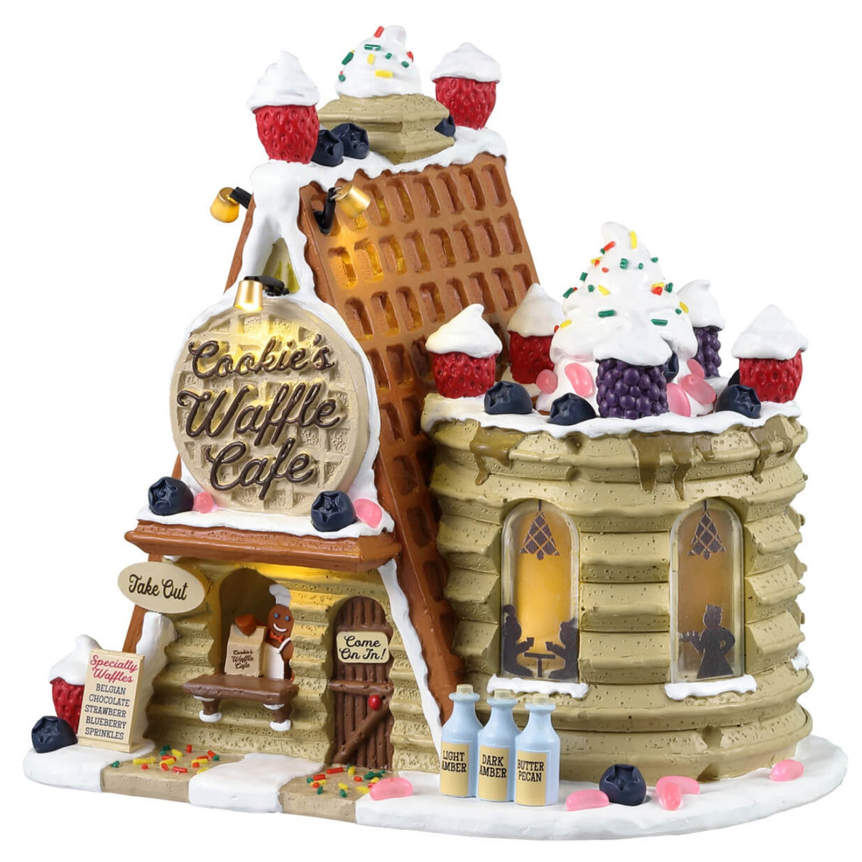 Resin lighted building for a Lemax Village display. Designed to look like a stack of pancakes and a roof made of waffles. The tops are decorated with whipped cream, sprinkles, raspberries, blackberries and pink jelly beans. The sign reads "Cookie's Waffle Cafe." There's a gingerbread person sitting behind the counter
