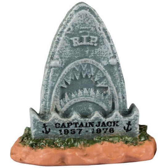 Resin village accents for a Lemax display. Designed to look like three tombstones. One is shaped like a shark and reads "Captain Jack 1957-1978." One is shaped like a pumpkin and reads "Ichabod Crane 1730-1789. Lost his head." The other is shaped like a Ouija board with a witch hat on top and has a black cat sitting on it.