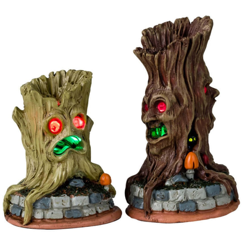 Plastic accessories for a Lemax display. Designed to look like two spooky tree trunks with glowing red eyes and glowing green mouths.