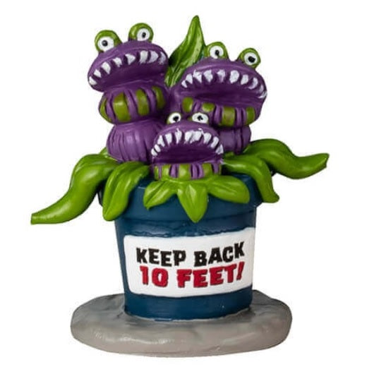 Resin table accents for a Lemax display. Designed to look like five really weird, alive plants. One looks like a bunch of green snakes coming out of a pumpkin. One is purple flowers with eyes and blue flowers in a black pot with blood coming out of it. One is red flowers with eyes and the pot reads "Do Not Touch." One is a Venus fly trap and the pot reads "Beware." The other is a purple Venus fly trap and the pot reads "Keep Back 10 feet."