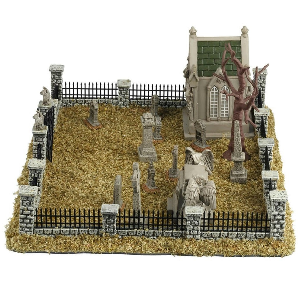 Resin village accent for a Lemax display. Designed to look like a graveyard full of dead grass. There are tombstones and headstones and mausoleums. There's also a bare tree and a metal fence with stone columns.