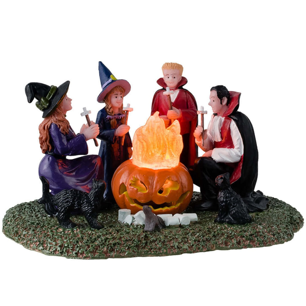 Resin table accent for a Lemax display. Designed to look like four kids dressed in costumes sitting around a fire roasting marshmallows. Two of the kids are dressed like witches and the other two are dressed like vampires. There are black cats and rats watching.