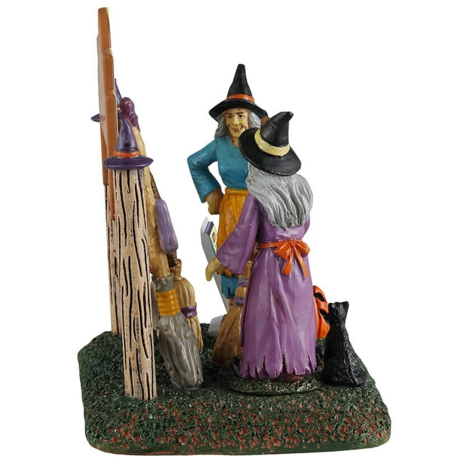 Resin table accent for a Lemax display. Designed to look like two witches storing their brooms at the broom rental spot.