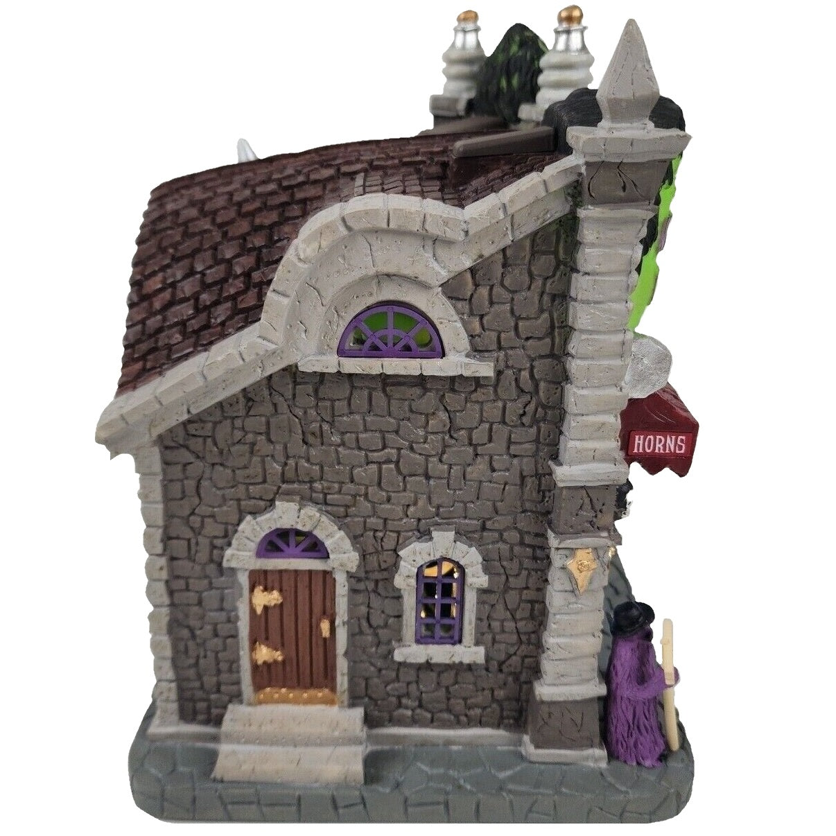 Resin lighted building for a Lemax display. Designed to look like a gothic wig store. The sign reads "WICKED WIGS" and looks like the top of Frankenstein's head. There's also a statue of the Bride of Frankenstein. There are skulls and pumpkins and cousin IT standing outside. They sell zombie wigs, vampire wigs, clown wigs and more.