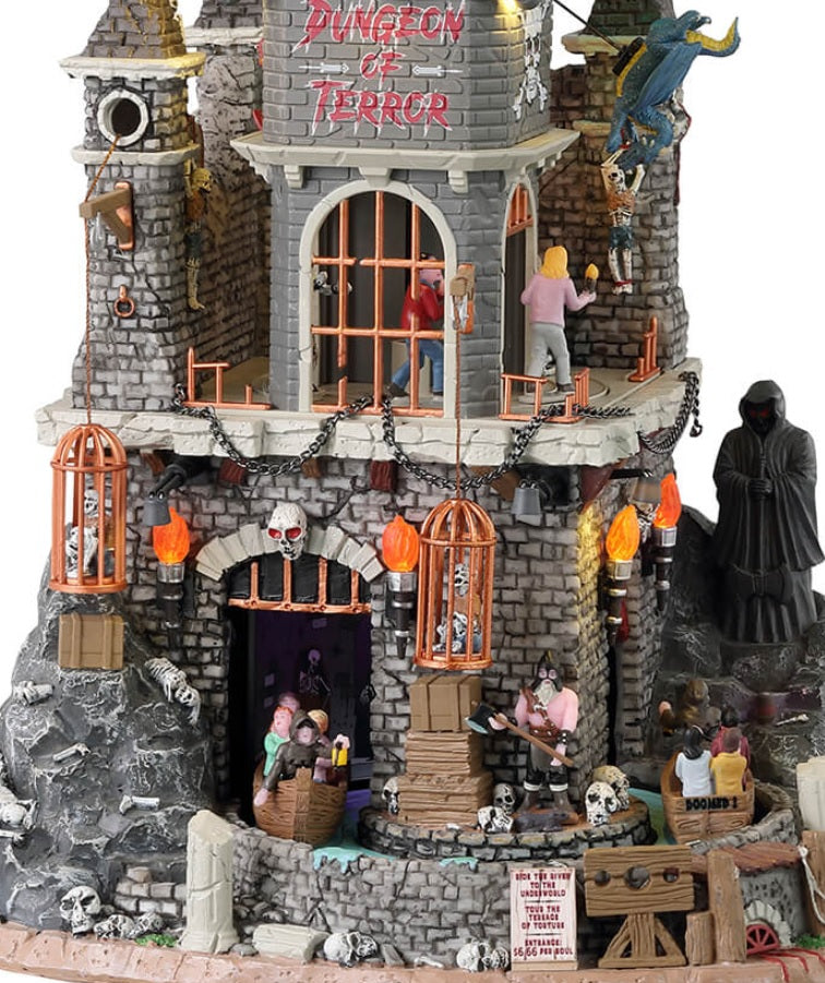 Resin lighted building for a Spooky Town display. Designed to look like a tall dungeon built into a stone mountain. There are dragons flying around the roof, a Grim Reaper off to the site and skeletons in cages. There's a ride that goes through the dungeon and there are kids in the carts.