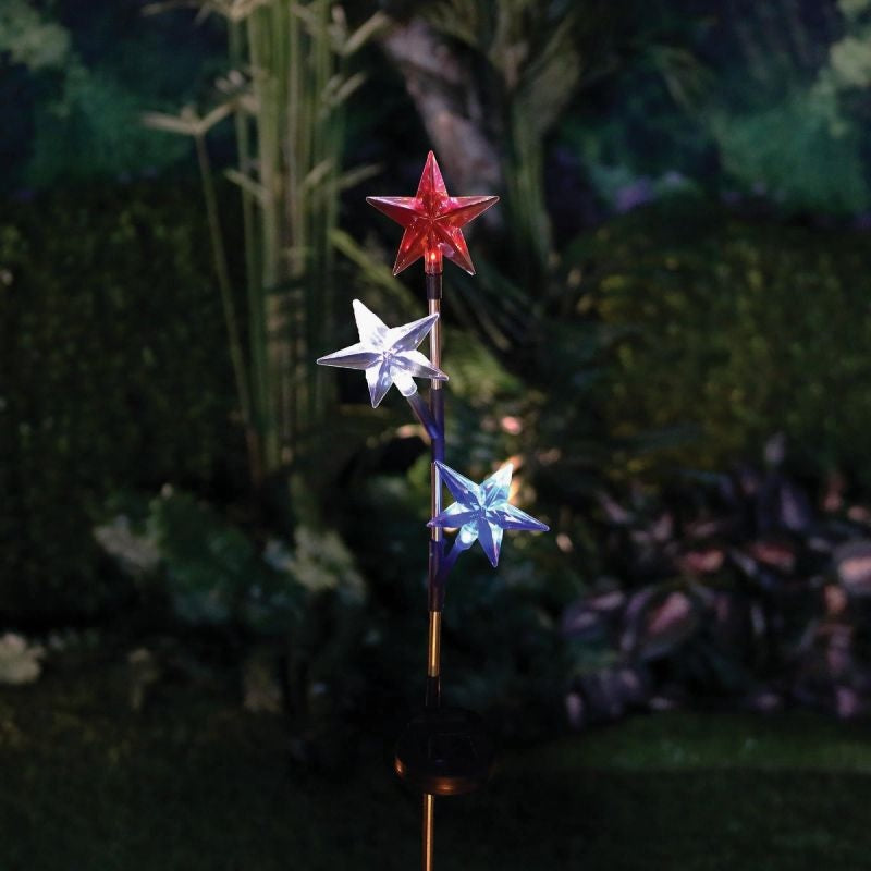 Solar powered garden stake with three stars on it. One star shines red, one star shines pure white and one star shines blue.