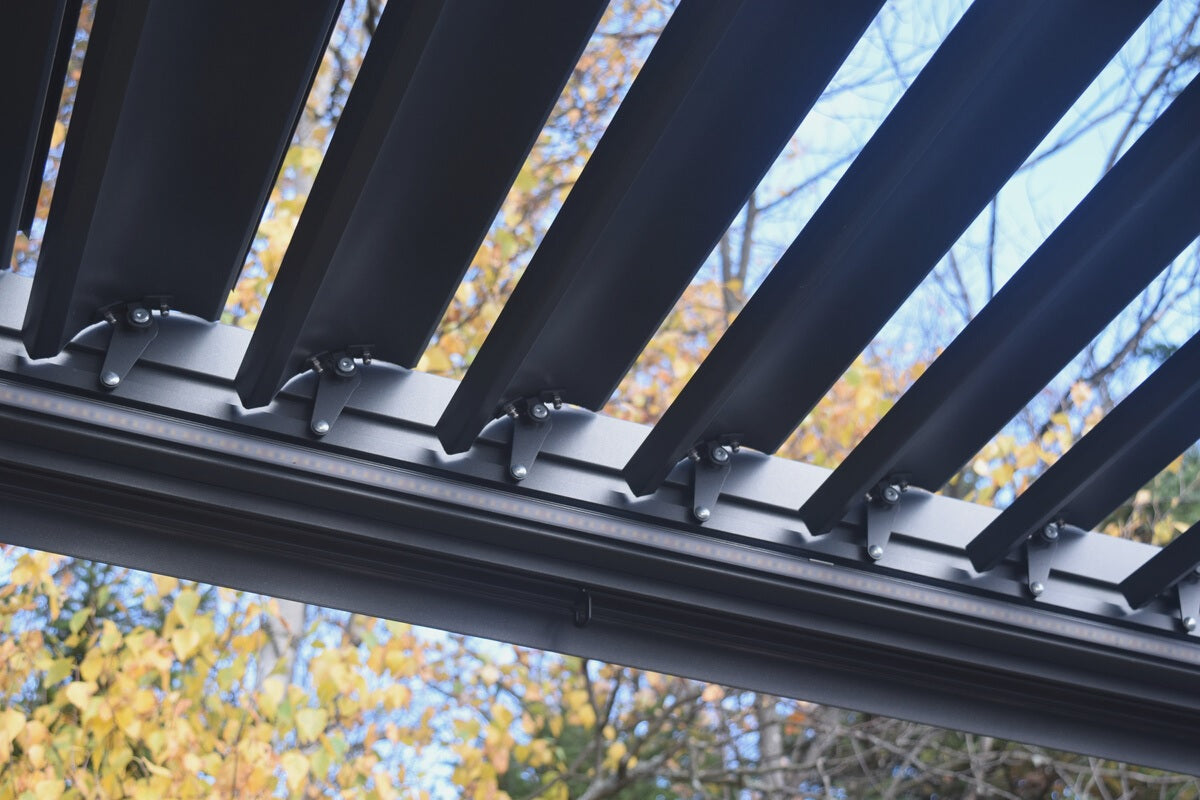 This is a lifestyle image showing the moveable roof slats from underneath. In this picture, the slats are open slightly so you can see trees through them.