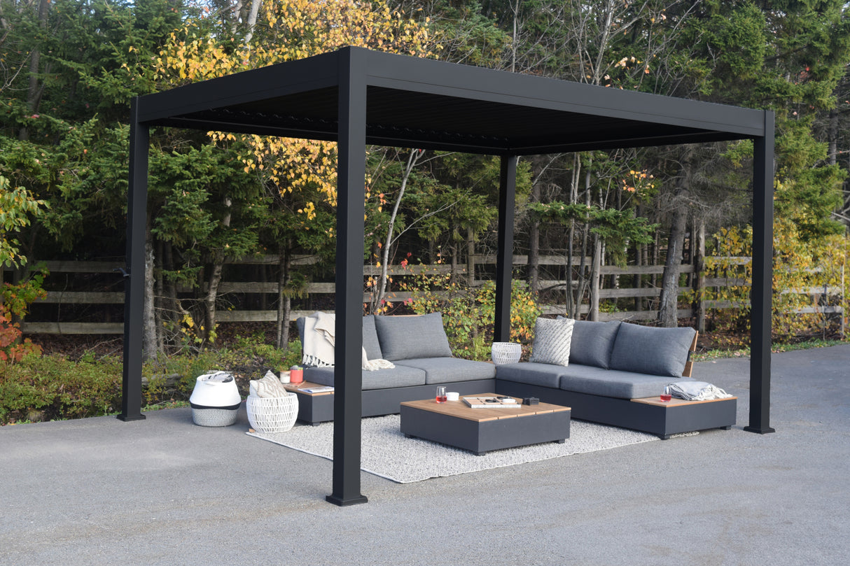 This is a lifestyle image showing the Georgetown sun shelter. The frame is a Charcoal gray color. Underneath the sun shelter, there are two outdoor loveseats with a table in the center.