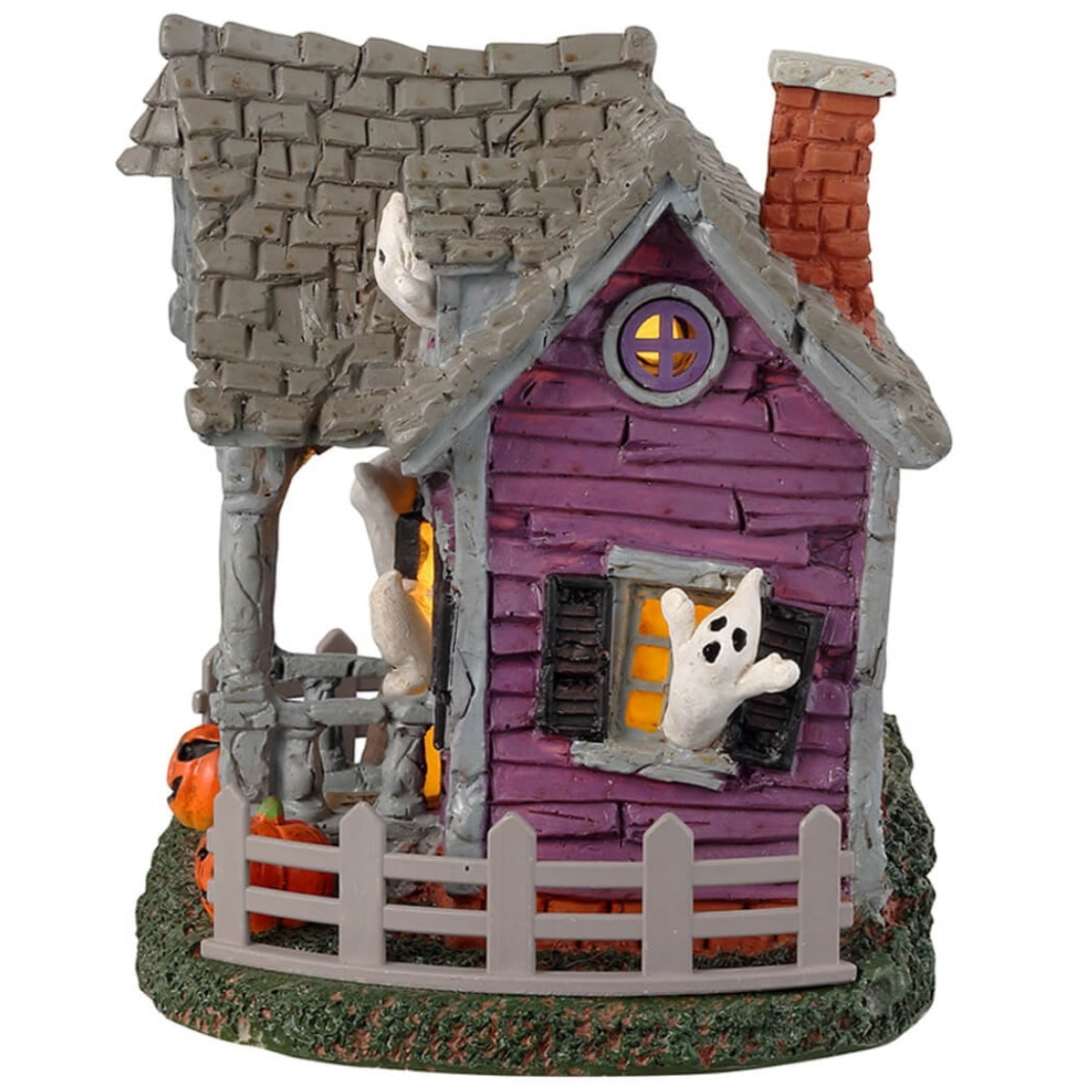 Resin village accent for a Lemax display. Designed to look like a purple, rundown house with ghosts coming out of the windows. There are jack-o-lanterns on either side of the porch and a gray fence around the house.