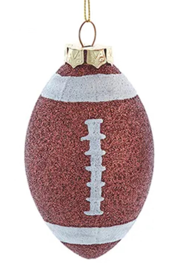 Ornament shaped like a football decorated with brown and white glitter.