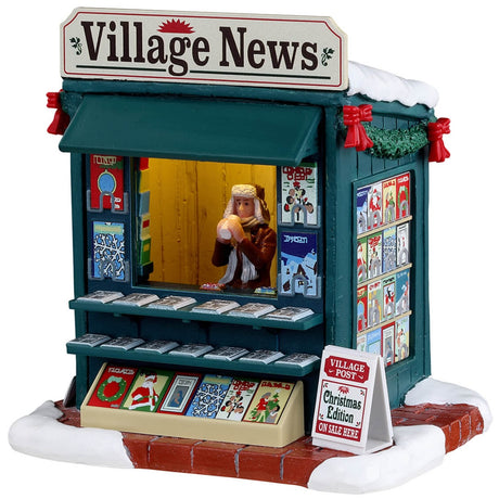Resin village accent for a Lemax display. Designed to look like a newspaper stand decorated for Christmas. The vendor inside is wearing a winter hat, scarf and coat and is drinking from a white cup.