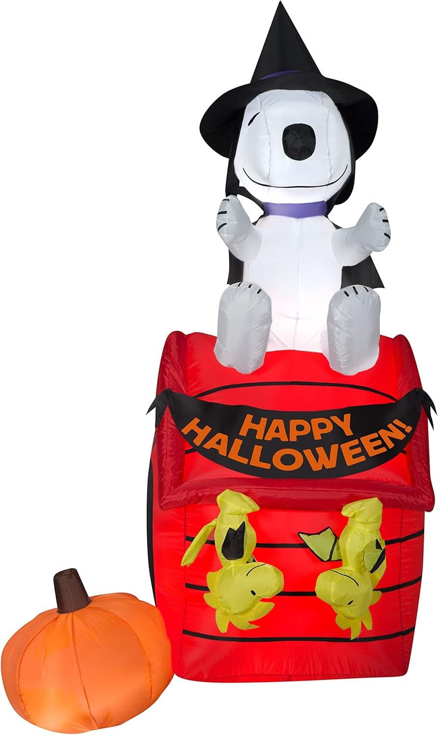Halloween inflatable shaped like Snoopy the Peanuts cartoon character dressed as a witch and sitting on his red dog house. There are two Woodstock Peanuts cartoon characters hanging from the house like they're bats and there's a pumpkin off to the side.