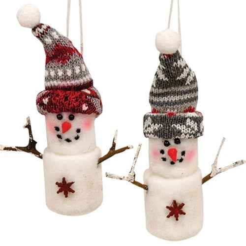 Marshmallow snowman ornament. One snowman is wearing a red knitted hat. One snowman is wearing a gray knitted hat. Both feature details like smiling faces with rosy cheeks, twig arms and snowflake charms.