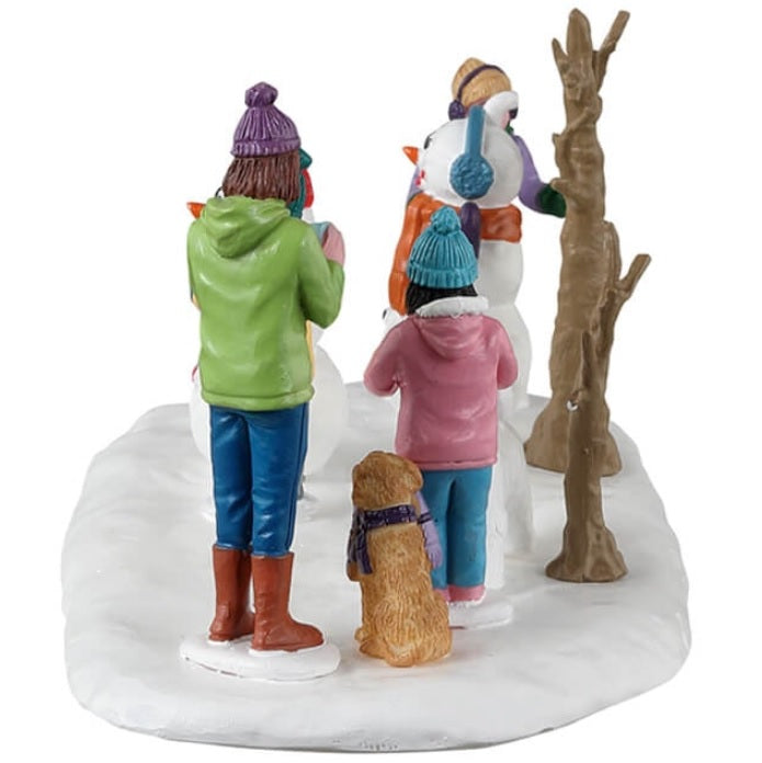 Resin village accent for a Lemax display. Designed to look like a group of people putting clothes on snowmen.