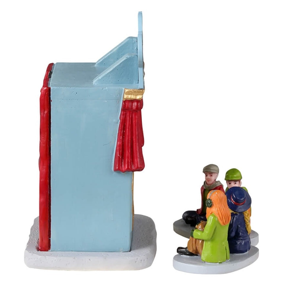 Resin village accent for a Lemax display. Designed to look like a booth decorated to look like a mini theatre with a red curtain. There are two puppets inside and four kids watching.