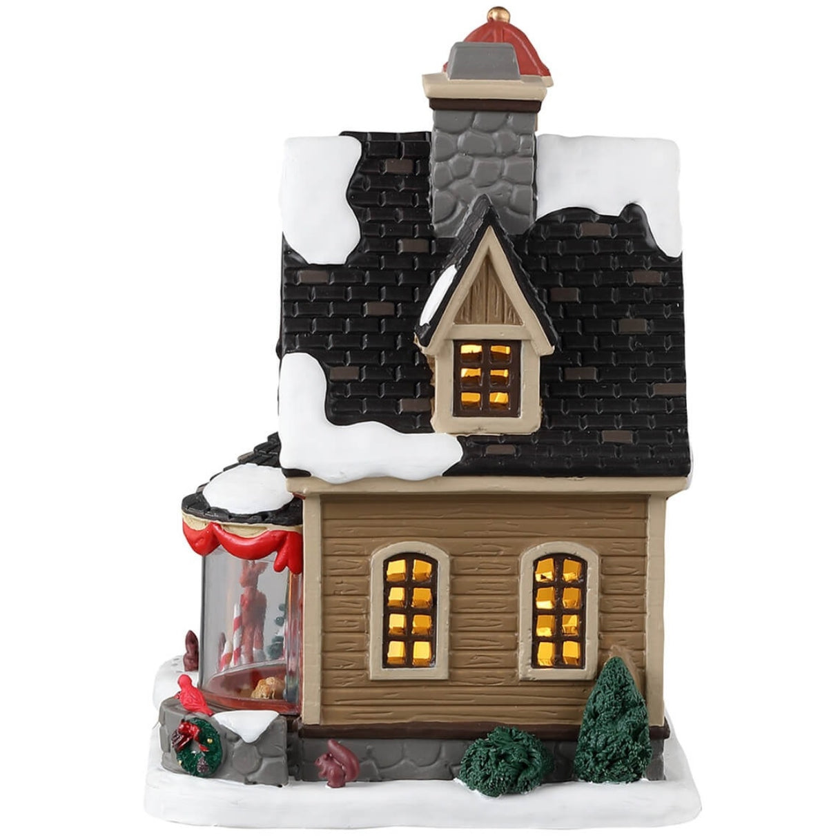 Porcelain lighted building for a Lemax display. Designed to look like a cute home decorated for Christmas. There's snow on the roof and on the sidewalk. There are wreaths, red ribbons and candy cane accents. There's a reindeer and a squirrel near the front door. In the window, you can see a couple relaxing near a fireplace.
