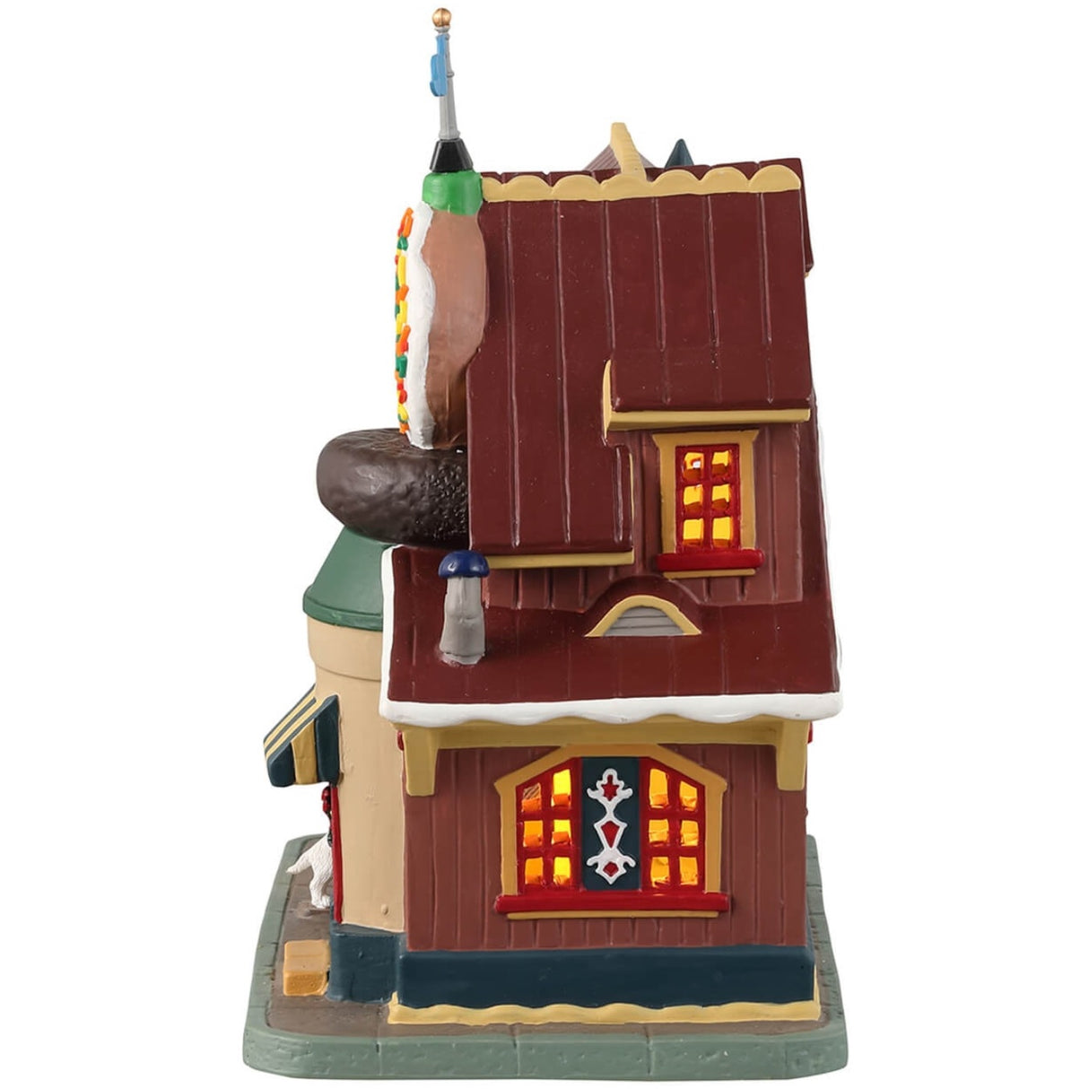 Porcelain lighted building for a Lemax display. Designed to look like a donut shop. There are multiple, large donut statues in front. There's a dog looking in the window at all the treats inside. There's also a vendor behind the booth waving to get your attention.