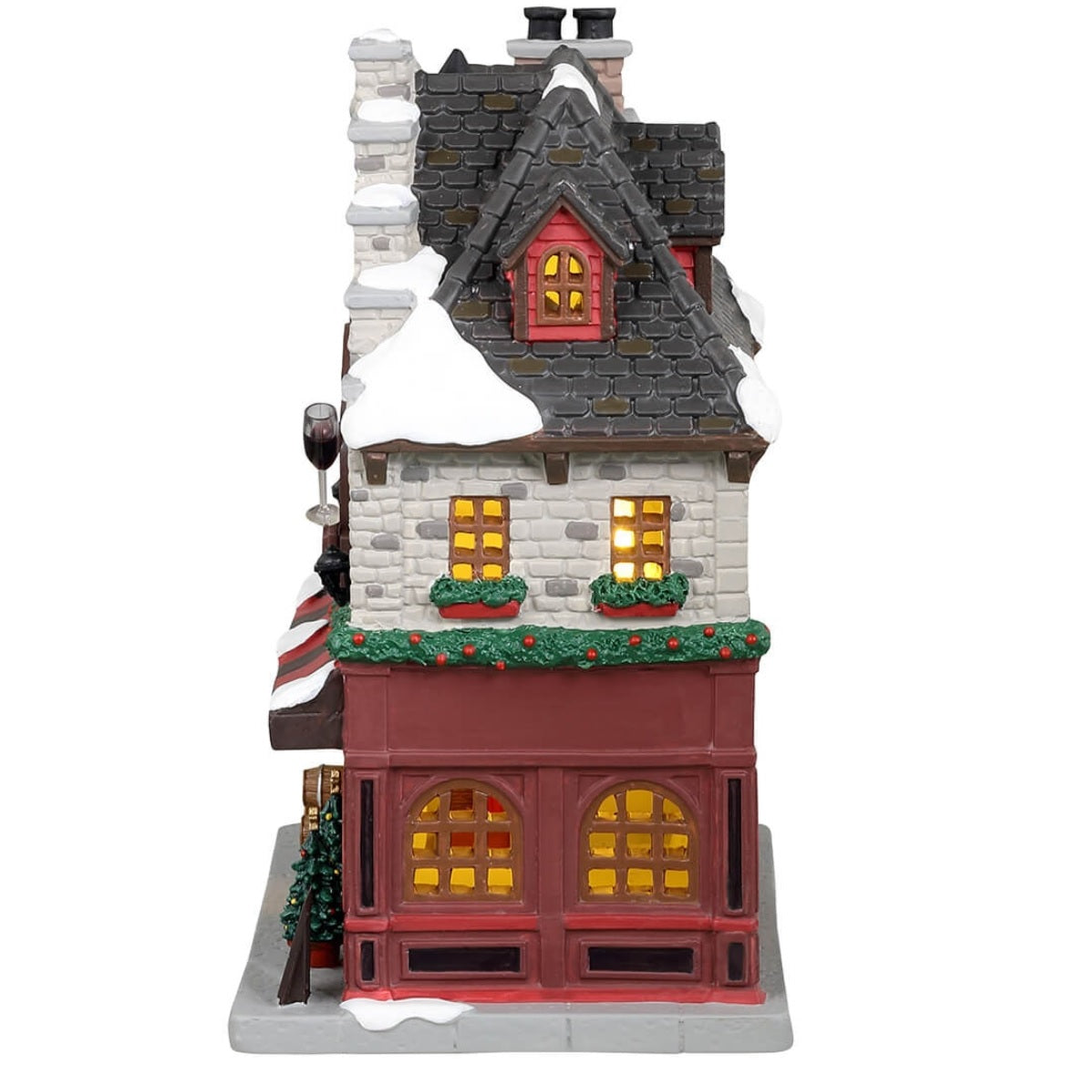 Porcelain lighted building for a Lemax display. Designed to look like a wine and chocolate tasting restaurant. There's a statue of a wine bottle, a wine glass and a piece of chocolate on the front. There are two decorated trees near the front door and a bunch of barrels on the sidewalk.