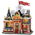 Resin lighted building for a Lemax display. Designed to look like building decorated for Christmas. There are three large mug statues on the roof and a large red flag that reads "TEA WITH MRS. CLAUS."