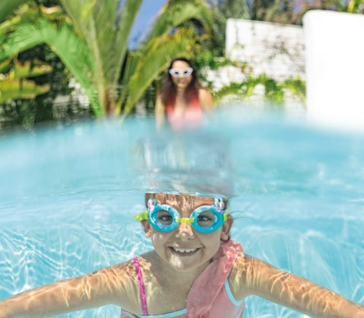 Fun swimming goggles for kids. One features light blue eye cups with pink butterflies and flowers on it with a yellow strap. One features red eye cups that are shaped like crabs with a yellow strap. One features blue eye cups with light blue smiling sharks and a gray strap.