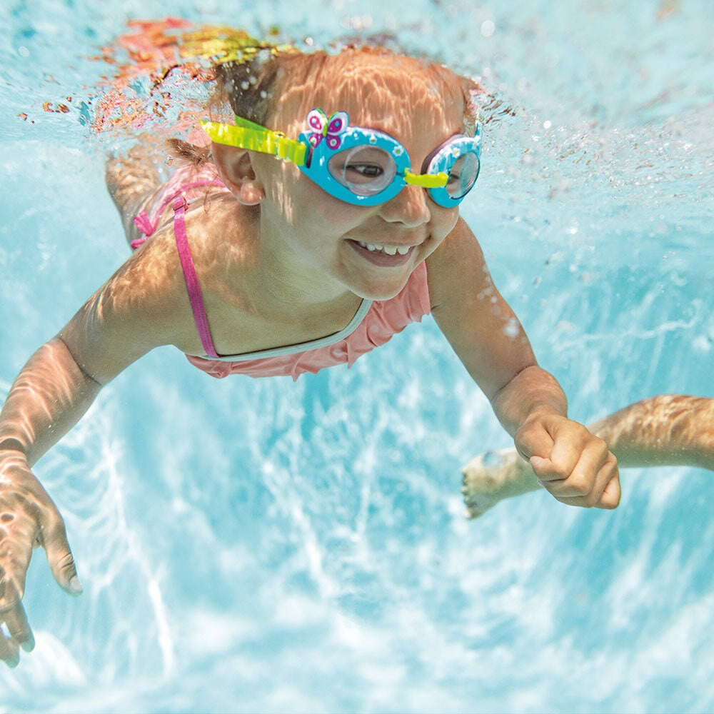 This is a lifestyle image showing a young girl underwater wearing the butterfly goggles.