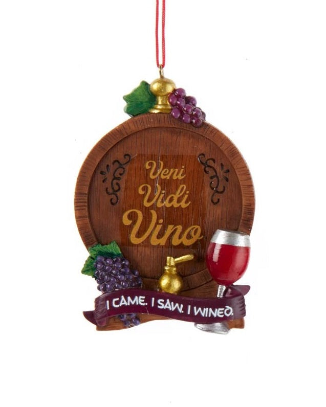 Wine-themed ornament. There are two options. One ornament features a barrel and reads "Veni Vidi Vino I cam I Saw I wined." One ornament features a bucket of wine bottles and reads "Wine Tasting Daily." Each ornament is decorated with grapes, wine glasses and wine bottles.