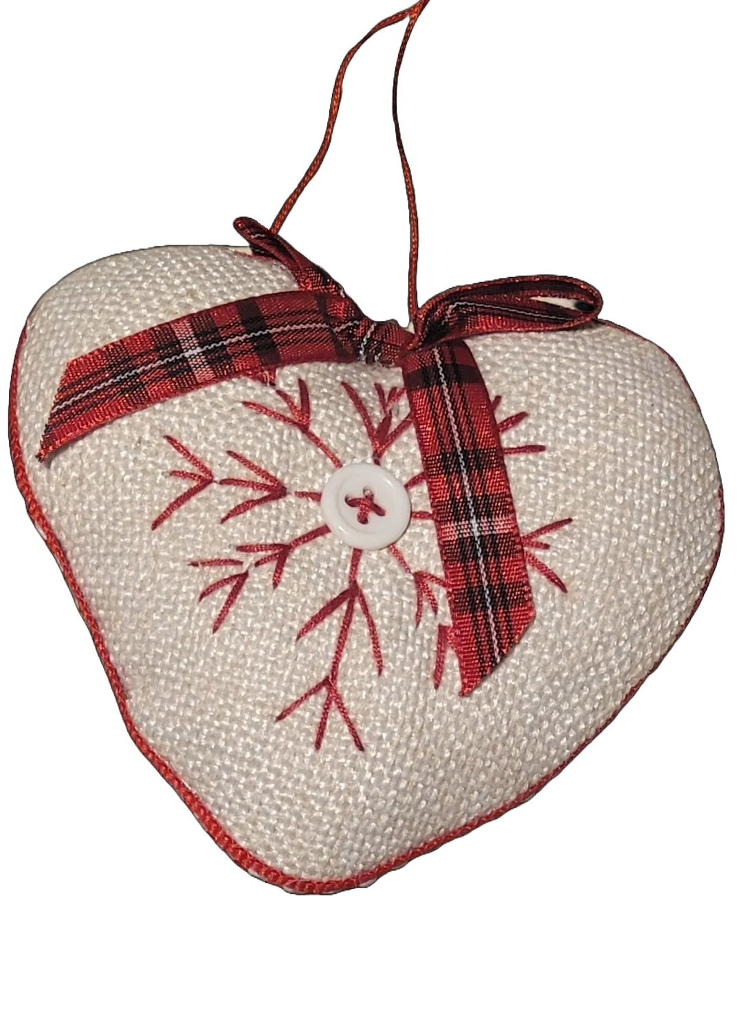 Heart-shaped Christmas ornament. One ornament is red with a white snowflake in the center. One ornament is white with a red snowflake in the center.