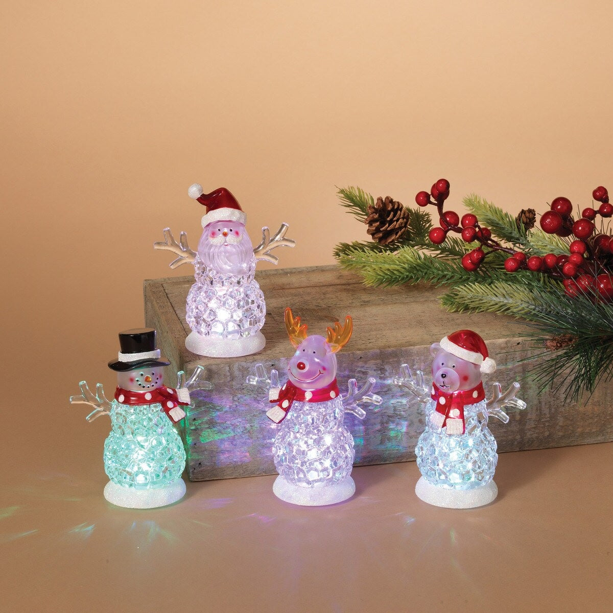 Tabletop decorations shaped like snowmen. One is a Santa "snowman," one is a reindeer "snowman," one is a bear "reindeer" and one is a traditional snowman. The belly of each looks like they're made of ice. There are lights inside that change colors.