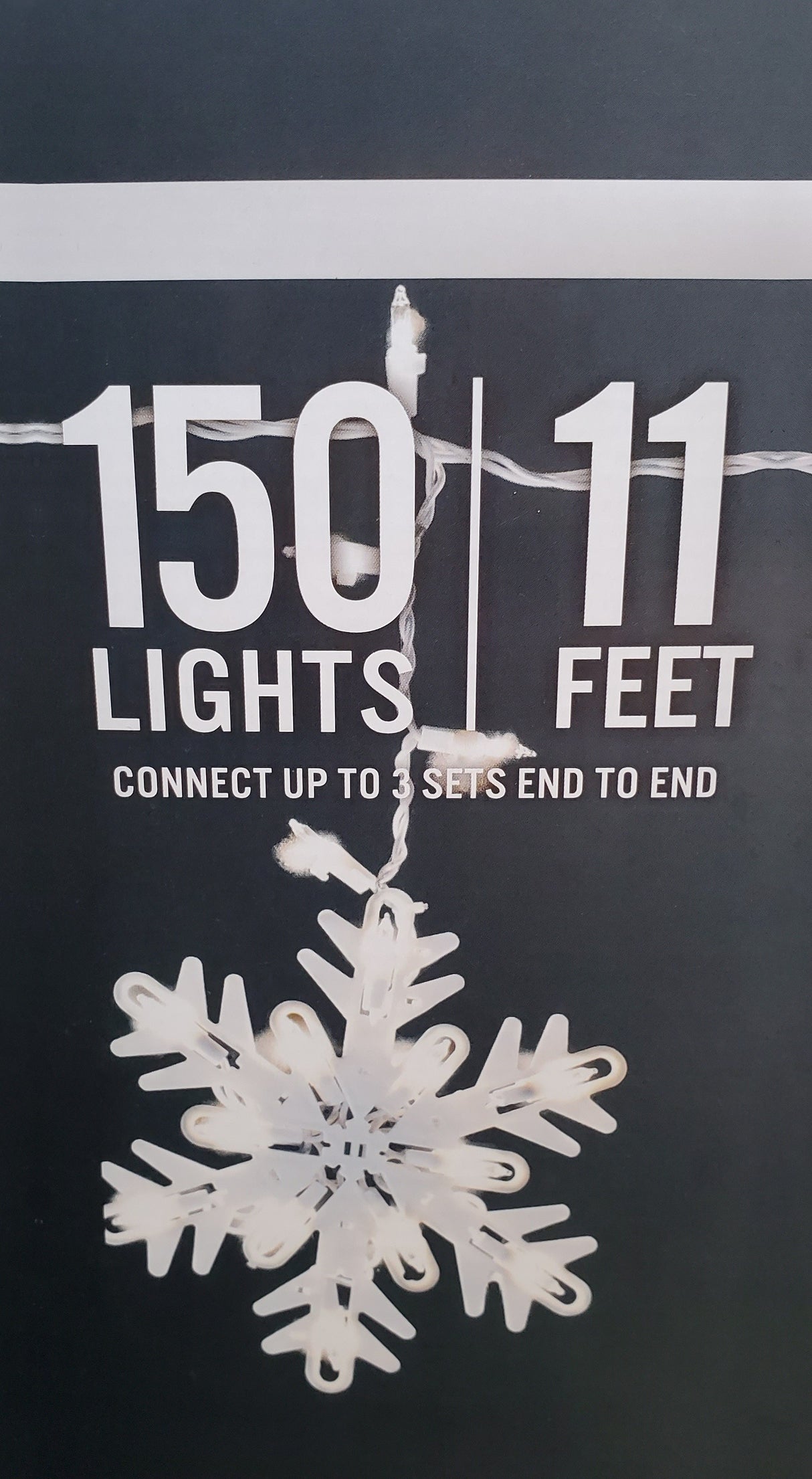 This image shows the side of the box these lights come in. It reads "150 lights. 11 ft. Connect up to 3 sets end to end" and it shows one of the snowflake lights.