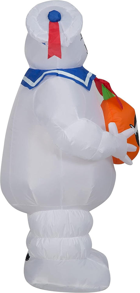 Halloween inflatable shaped like the Stay Puft Marshmallow Man from the movie Ghostbusters. He's holding a pumpkin with the Ghostbusters logo on it.