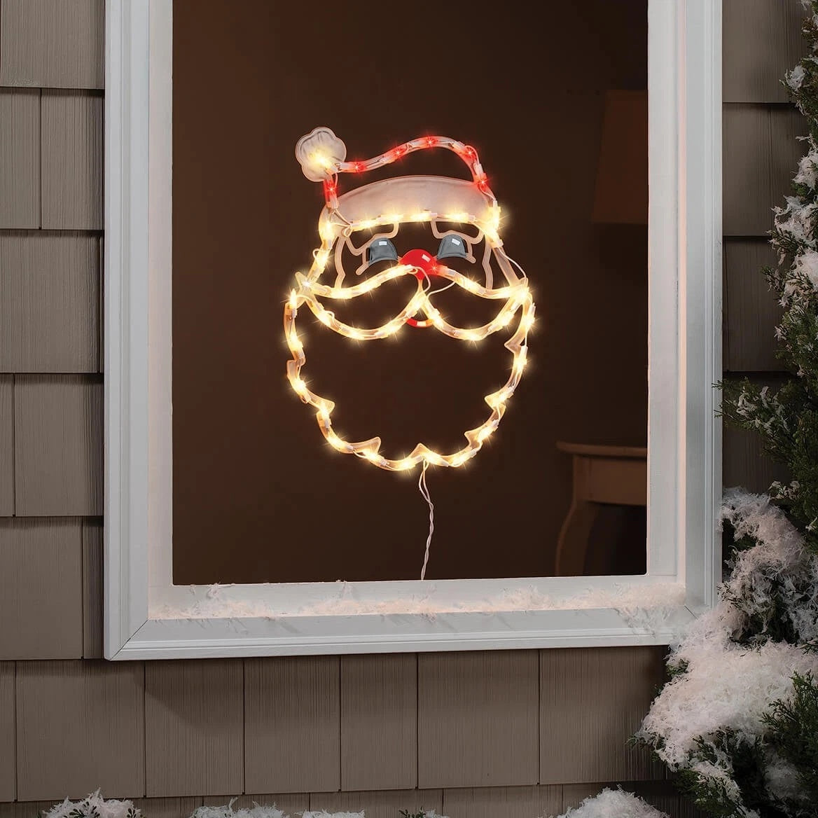 This is a lifestyle image showing the Santa head silhouette hanging in a window.