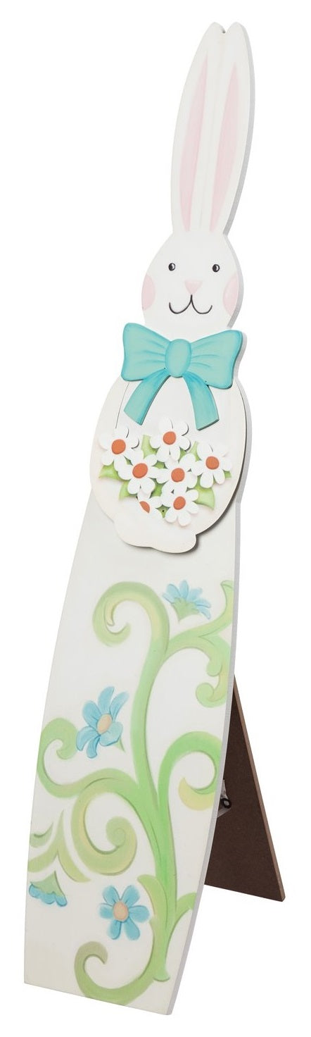 A porch decoration shaped like a tall bunny. Bunny is wearing a teal bow and holding a bunch of flowers. Features four blue flowers and green stems at the base