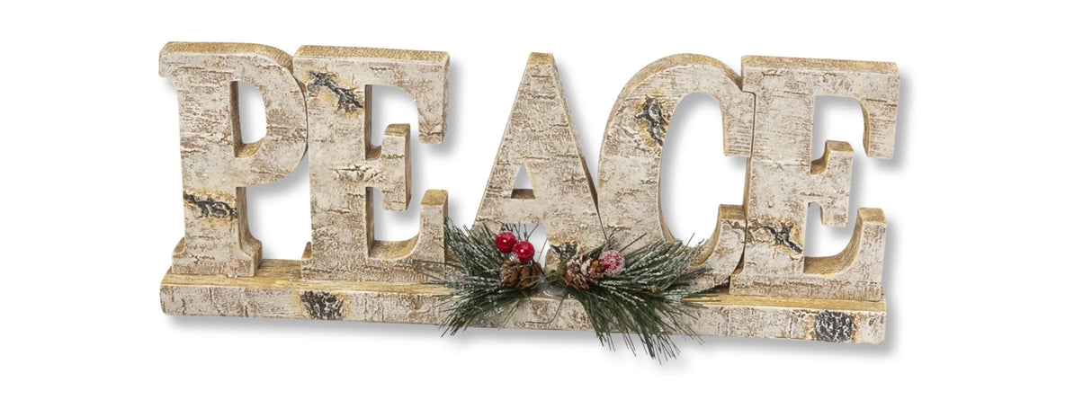 Tabletop decoration that looks like it was carved out of birch wood. This one reads "PEACE" and features pine cone, pine needle and berry accents.