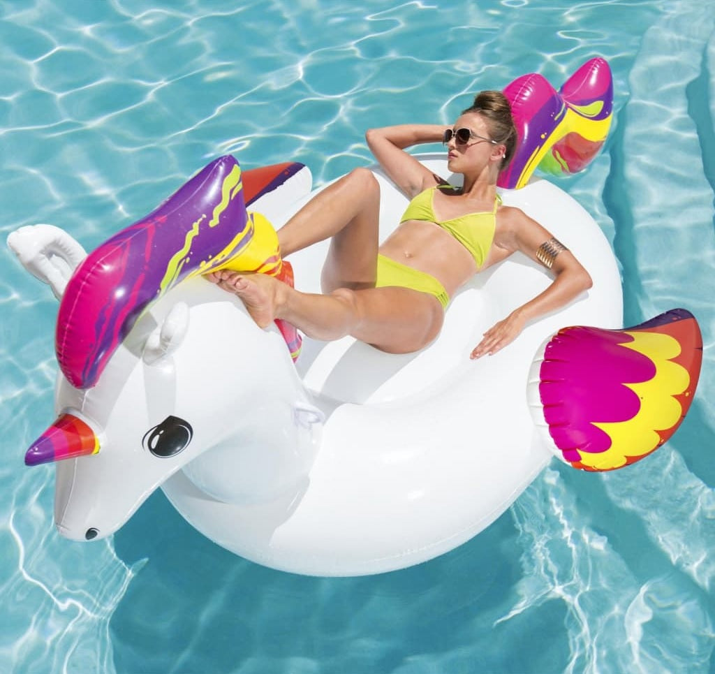 Inflatable pool float shaped like a white and rainbow unicorn.