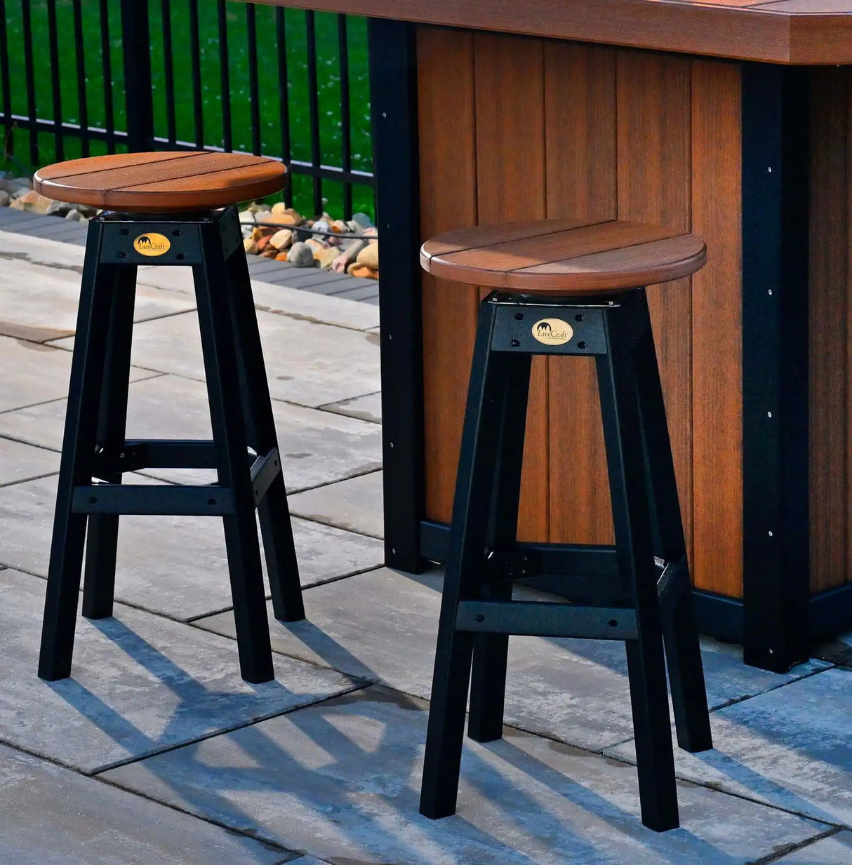This is a lifestyle image showing two Antique Mahogany and Black colored bar stools in front of a matching table.