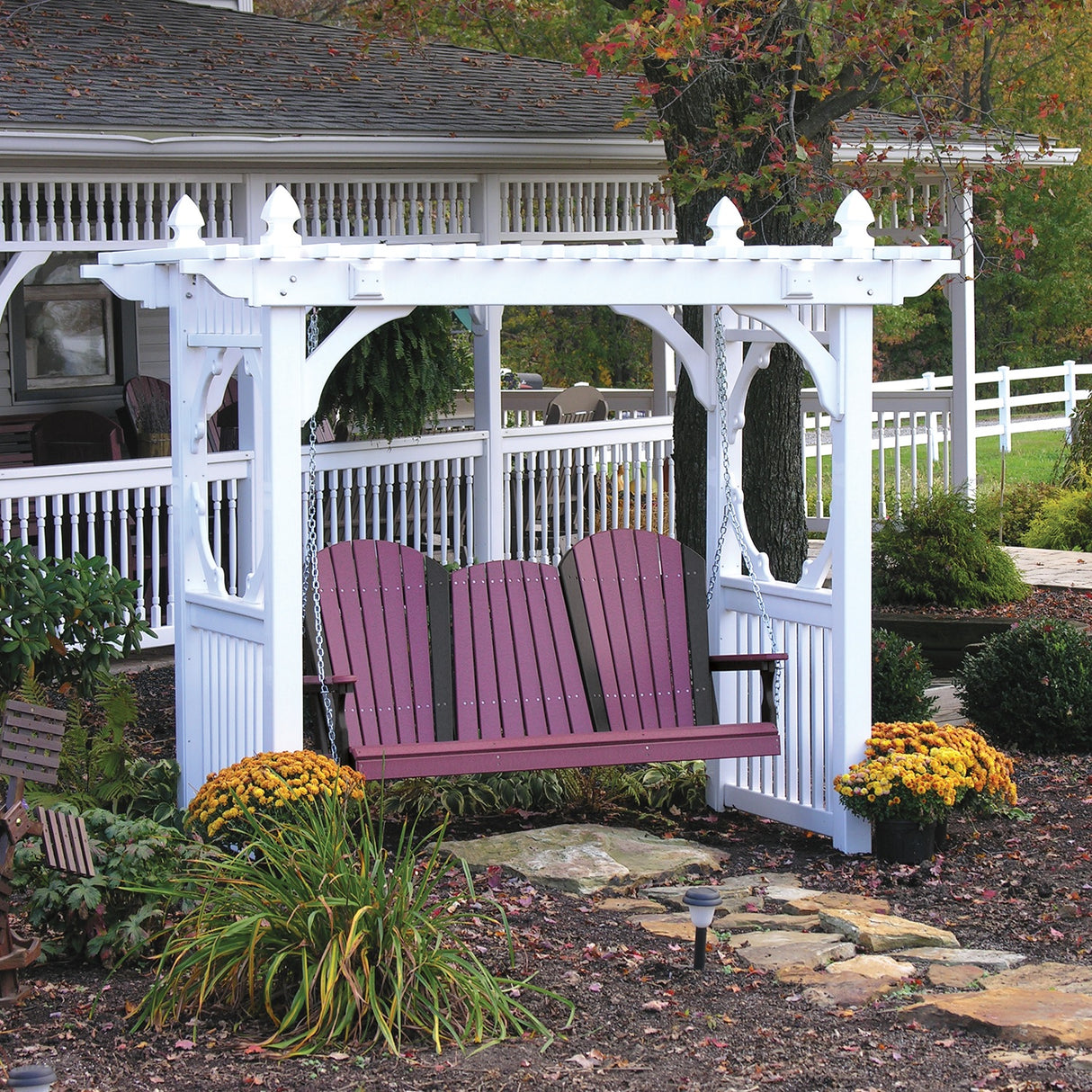 This is a lifestyle image showing the White colored classic vinyl swing stand with a Cherrywood and Black colored bench hanging from it.