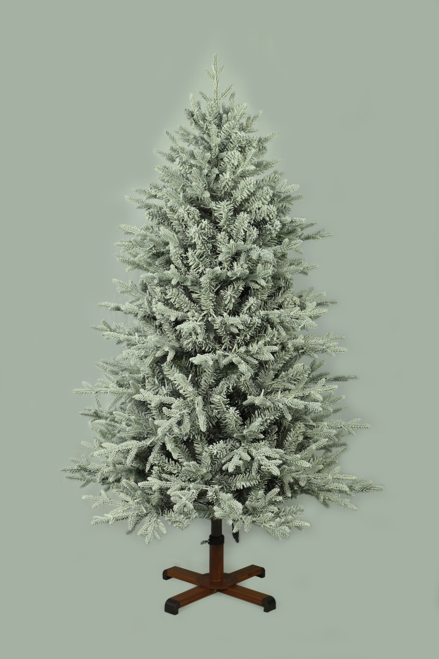 This image shows the flocked Christmas tree with the lights turned off. The tree is up against a light gray background.