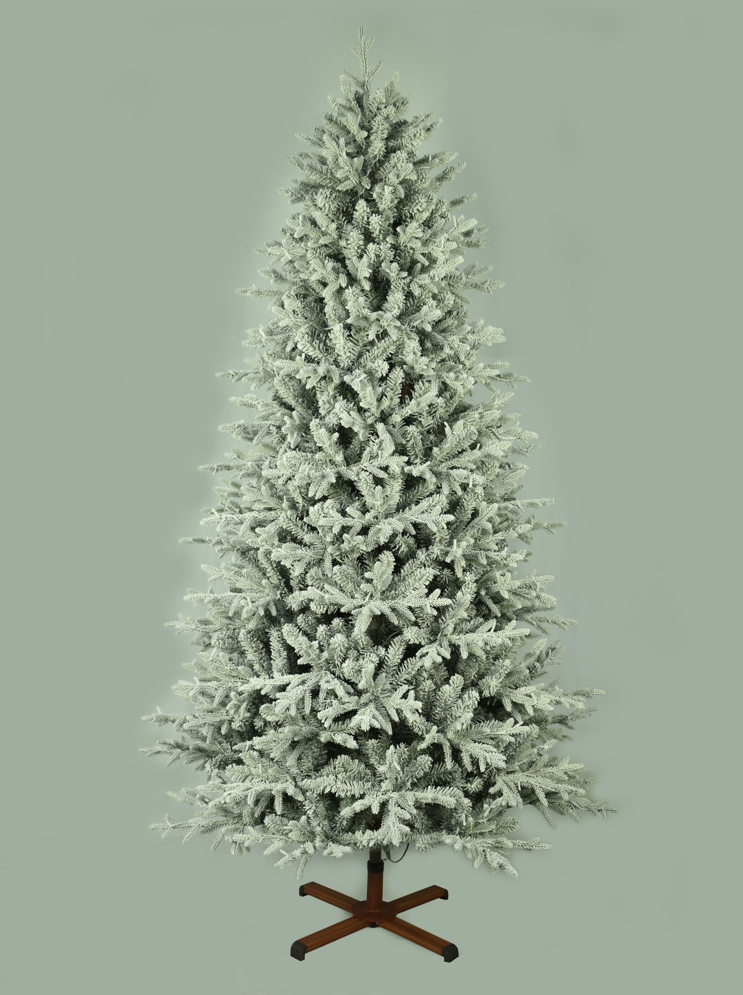 This image shows the flocked Christmas tree with the lights turned off. The tree is up against a light gray background.