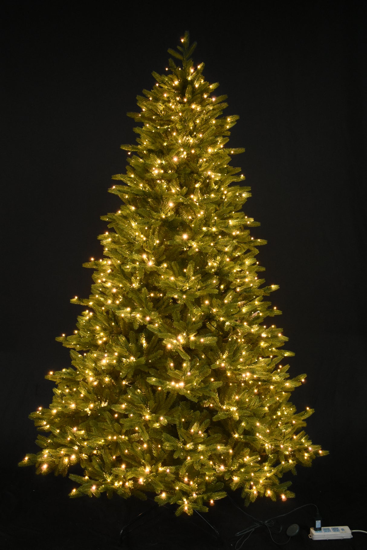 Artificial tree pre-lit with warm white starry LED lights.