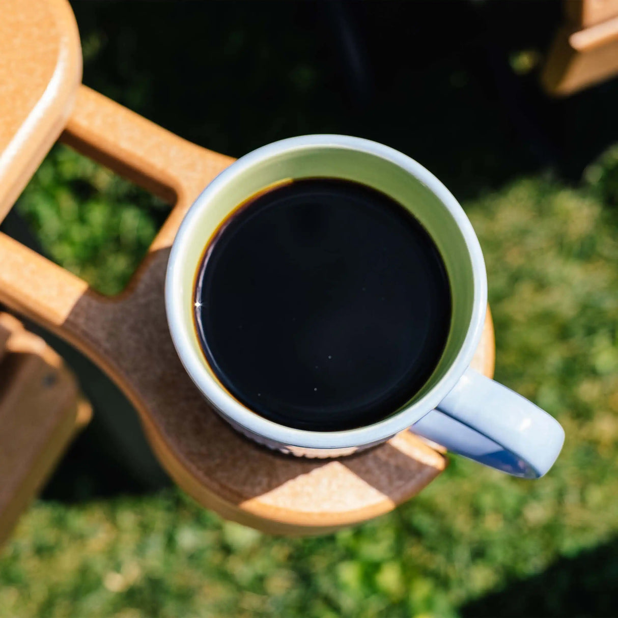 This is a lifestyle image from above showing a mug of coffee resting inside the Cedar colored cup holder.