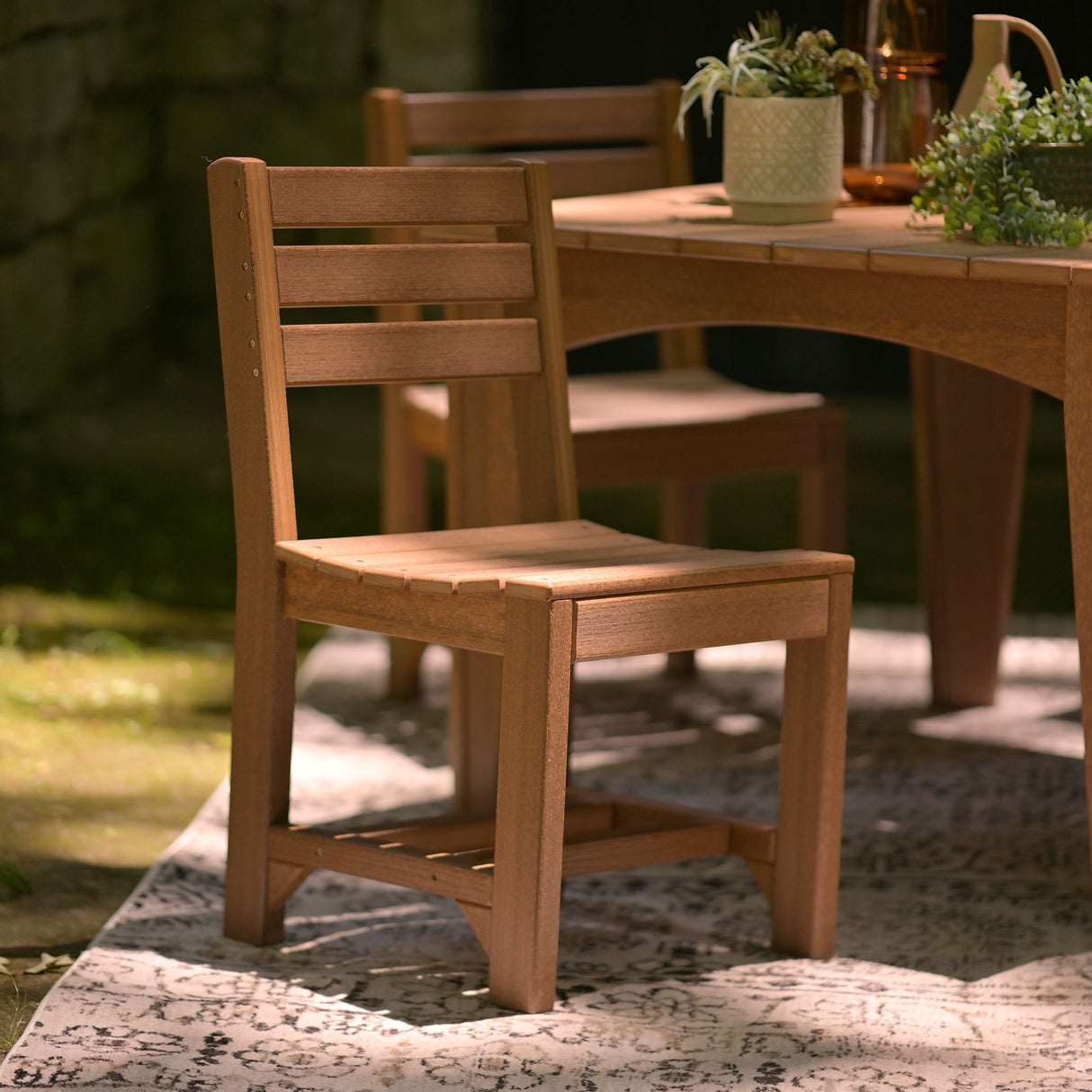 This is a lifestyle image showing Antique Mahogany colored Side Chairs around a matching table on an outdoor patio.