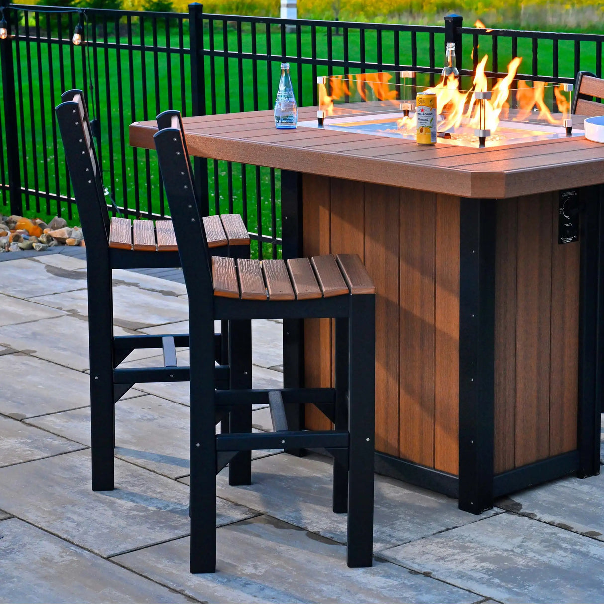 This is a lifestyle image showing two Antique Mahogany and Black colored side chairs next to a matching fire pit table.