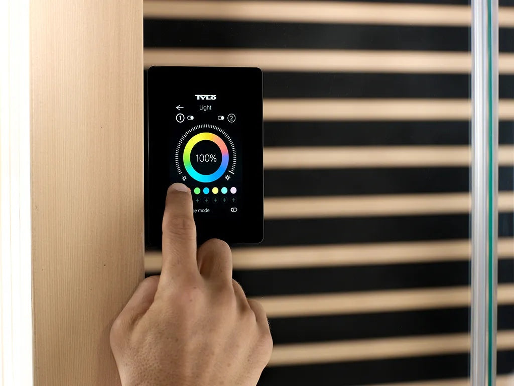 This image shows a person using the control pad in the sauna to adjust the temperature.