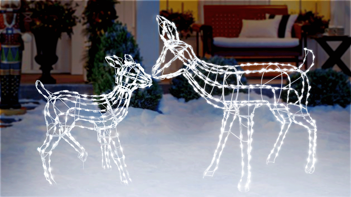 This animated image shows the fawn and the doe wire sculptures kissing noses on a snowy front lawn.