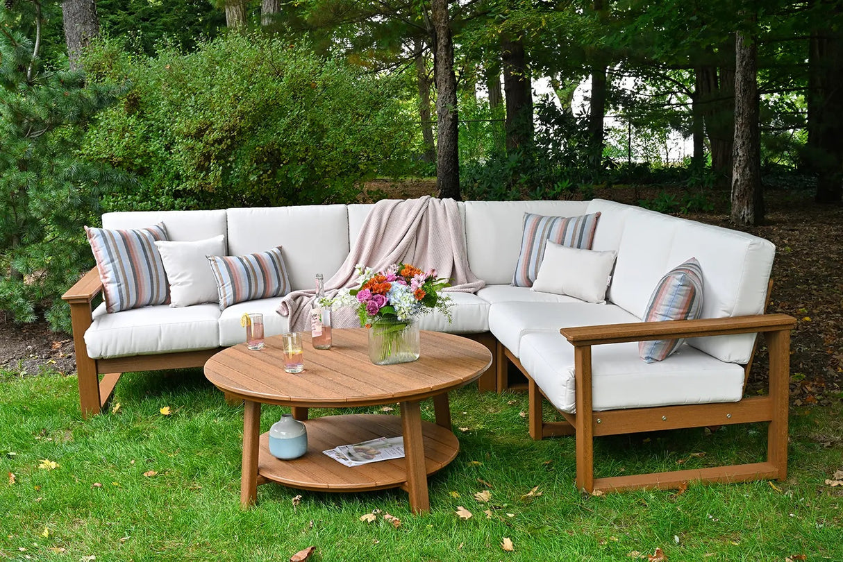 This is a lifestyle image showing an outdoor sofa with Antique Mahogany frames and Canvas colored cushions.