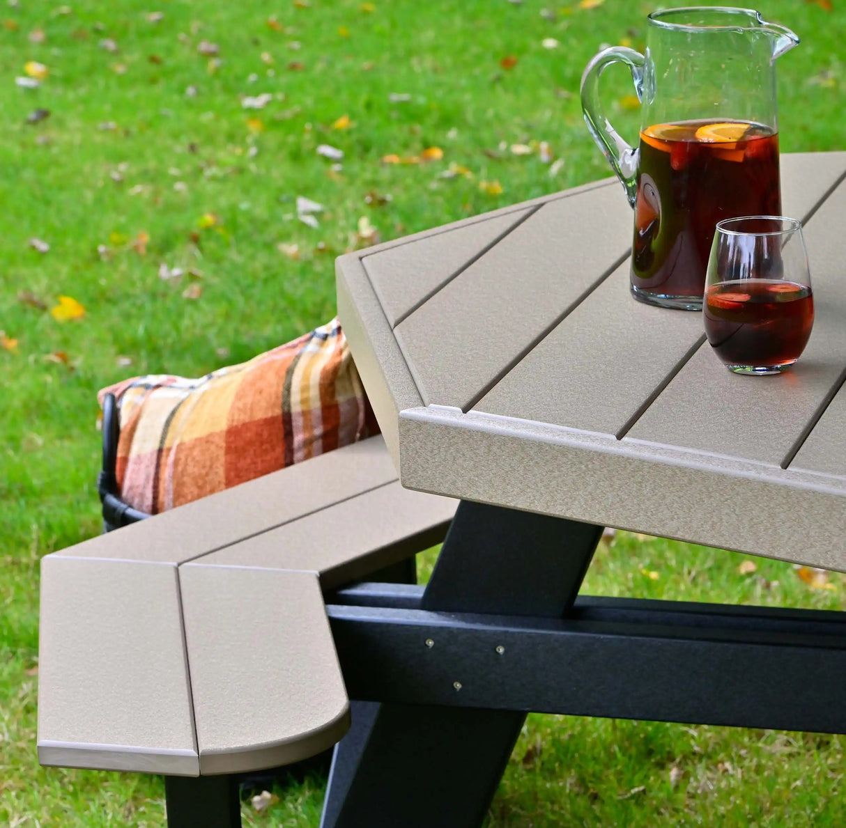 This is an up close view of the Weatherwood and Black colored picnic table with a pitcher of sangria on the table.