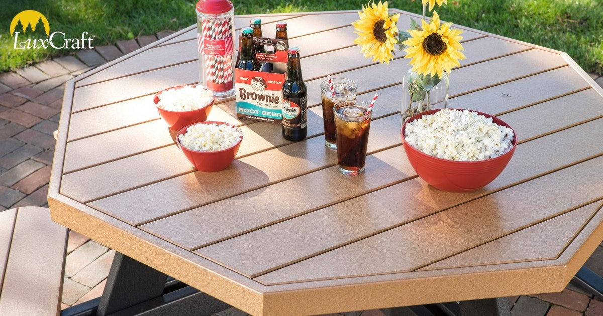 This is an up close view of the Cedar and Black colored picnic table. There are a few bowls of popcorn and bottles of root beer.