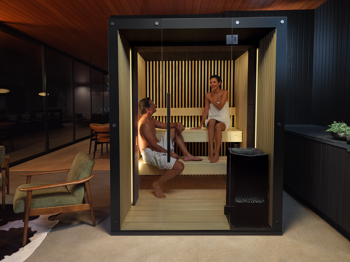 This image shows two people inside of a sauna inside their home.