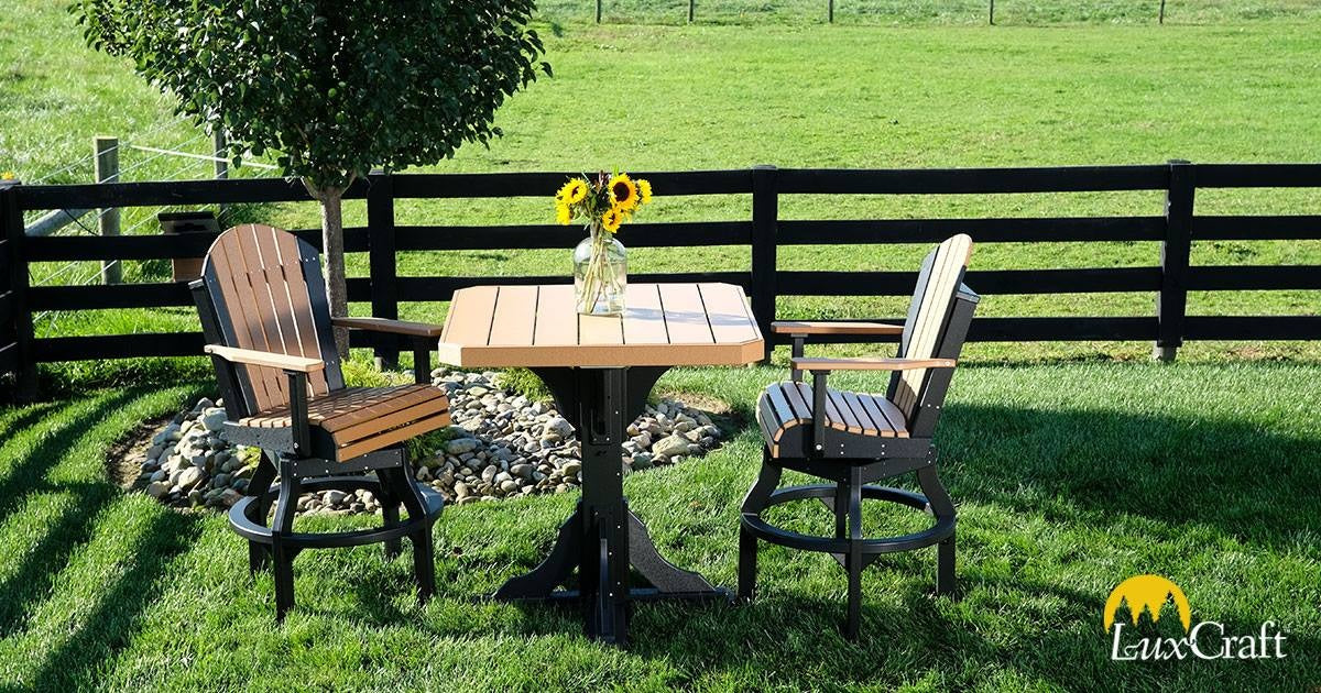 This is a lifestyle image showing two matching Weatherwood and Black colored swivel Adirondack chairs with a matching table between them.